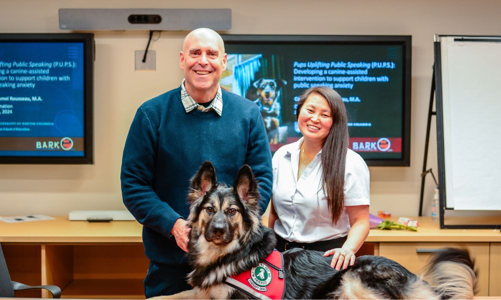 Dr. John-Tyler Binfet stands next to Camille Rousseau with dog in front of them